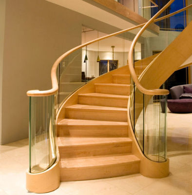 A escadaria curvada moderna revestida da grão de madeira fácil instala com trilhos de vidro